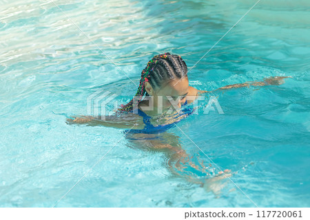 Little girl is exercising in the pool. Little girl is exercising in the pool. 117720061