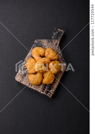 Delicious fresh crispy chicken nuggets on a dark concrete background Delicious fresh crispy chicken nuggets on a dark concrete background 117720544