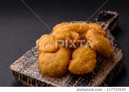 Delicious fresh crispy chicken nuggets on a dark concrete background 117720545