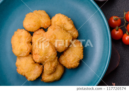 Delicious fresh crispy chicken nuggets on a dark concrete background 117720574