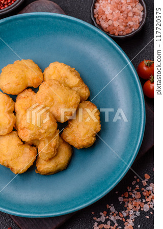 Delicious fresh crispy chicken nuggets on a dark concrete background Delicious fresh crispy chicken nuggets on a dark concrete background 117720575