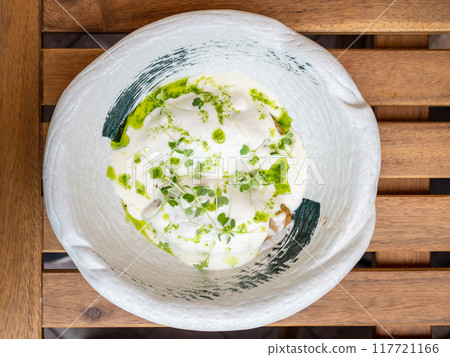bechamel and pesto sauce in bowl on wooden table 117721166