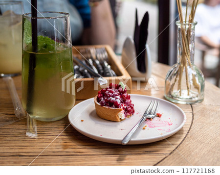 uneaten tartlet with berries and glass of lemonade uneaten tartlet with berries and glass of lemonade 117721168