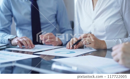 Business people are reviewing a financial results and discussing the terms of the agreement. Teamwork and planning 117722005