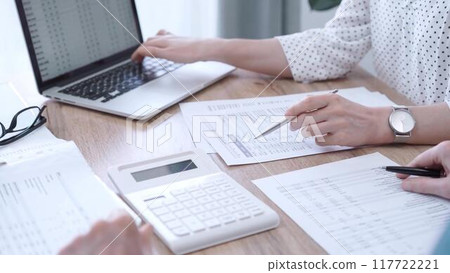 Professional female bookkeeper with a colleague are working on business finances. using calculator and laptop. Finance audit and taxes Professional female bookkeeper with a colleague are working on business finances. using calculator and laptop. Finance audit and taxes 117722221