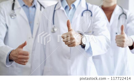 Group of doctors are are standing and showing thumbs up in hospital corridor. Medicine excellent service 117722414