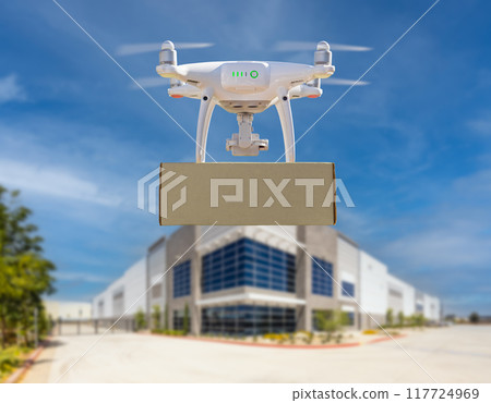 Unmanned Aircraft System (UAS) Quadcopter Drone Carrying Blank Package Near Corporate Commercial Building Unmanned Aircraft System (UAS) Quadcopter Drone Carrying Blank Package Near Corporate Commercial Building 117724969