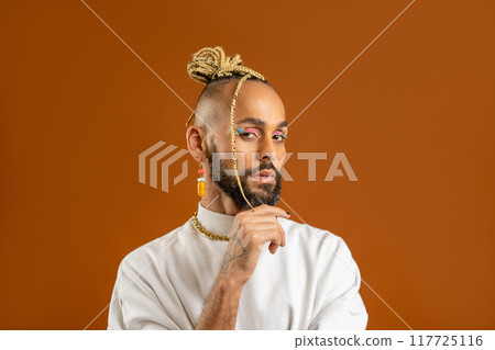 Black latin gay man isolated on orange background Black latin gay man isolated on orange background 117725116