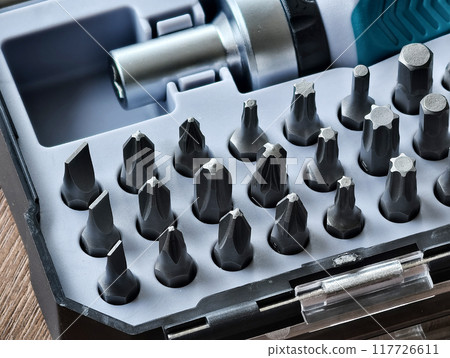 Various small screwdriver bits in different shapes and sizes, captured in a selectively focused image 117726611