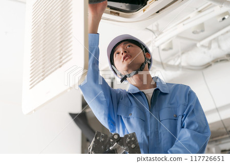 A worker inspecting an air conditioning system 117726651