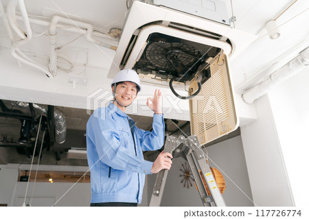 A worker inspecting an air conditioning system 117726774