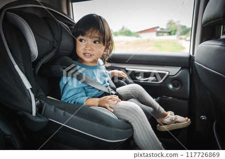 happy toddler girl sitting in car seat, safety baby chair travelling happy toddler girl sitting in car seat, safety baby chair travelling 117726869