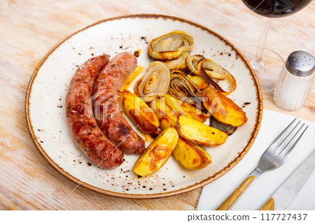Roast sausages with potatoes 117727437