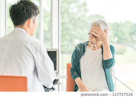 一位男醫師訪問一位老年婦女,她告訴醫生她在醫院/護理機構的健康狀況(身體檢查、身體檢查、體檢、健康檢查) 一位男醫師訪問一位老年婦女,她告訴醫生她在醫院/護理機構的健康狀況(身體檢查、身體檢查、體檢、健康檢查) 117727526