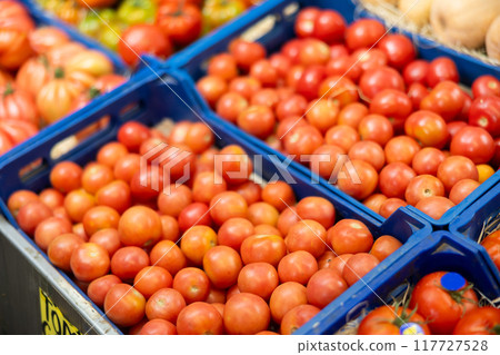 Pile of tomatoes lie on counter in shop 117727528