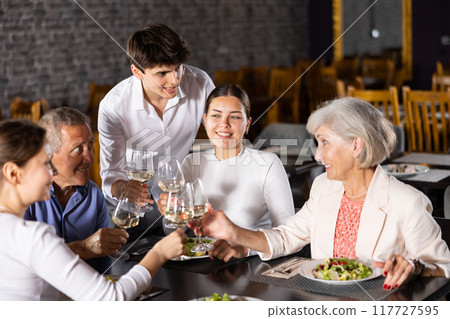 Large family, company of spouses in restaurant, eat, celebrate important event, communicate. Large family, company of spouses in restaurant, eat, celebrate important event, communicate. 117727595