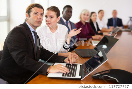 Female secretary chatting with her boss during conference Female secretary chatting with her boss during conference 117727737