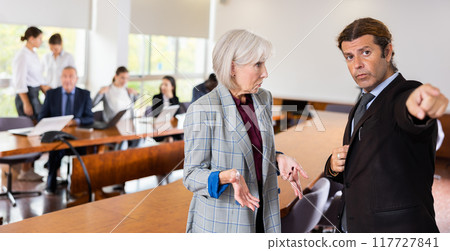 Angry businessman dismissing sad senior woman 117727841