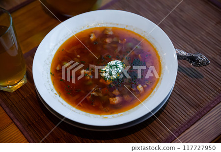 Traditional Russian meat soup Solyanka with sour cream and lemon 117727950