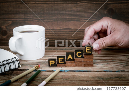 PEACE. Old letter tiles on wooden steps, development concept 117728607