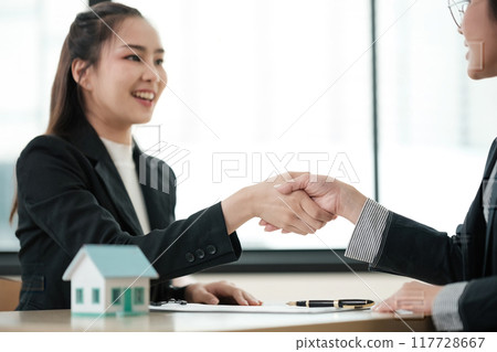 A woman shakes hands with another woman in a business meeting 117728667