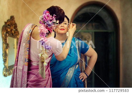 Capturing Camaraderie: Dancers in Vibrant Saris Perfect Their Look Together Before Cultural Celebration. Capturing Camaraderie: Dancers in Vibrant Saris Perfect Their Look Together Before Cultural Celebration. 117729583