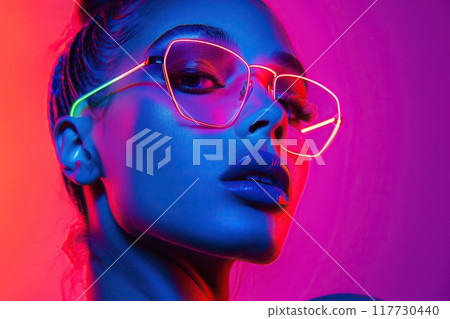 Close-up portrait of a beautiful woman in neon light. Studio shot. 117730440