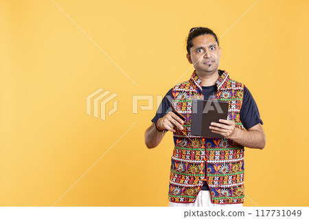 Portrait of irked indian man upset after lacking necessary money while trying to buy stuff online on tablet. Annoyed person frustrated after getting transaction rejected on digital device Portrait of irked indian man upset after lacking necessary money while trying to buy stuff online on tablet. Annoyed person frustrated after getting transaction rejected on digital device 117731049
