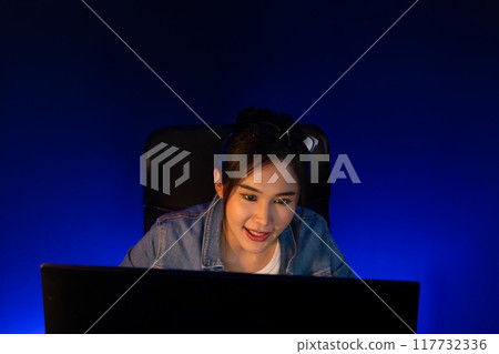 Smiling beautiful asian creative looking pc in sales target online. Stratagem. 117732336