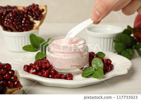 Cosmetics with pomegranate on a light background. Cosmetics with pomegranate on a light background. 117733023