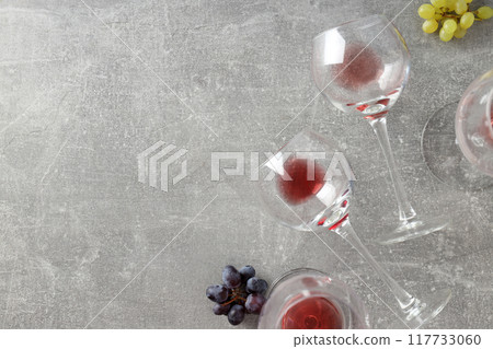 Glasses with wine and grapes, on a gray background. Glasses with wine and grapes, on a gray background. 117733060