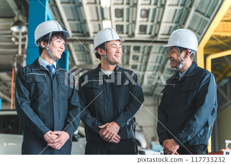 Male worker/businessman in work clothes standing in a factory/warehouse Male worker/businessman in work clothes standing in a factory/warehouse 117733232