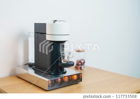 Espresso Coffee Maker Machine with Capsule of roasted coffee bean on wood table bar. Daily beverage drink at Home, Apartment and Office concept 117733508