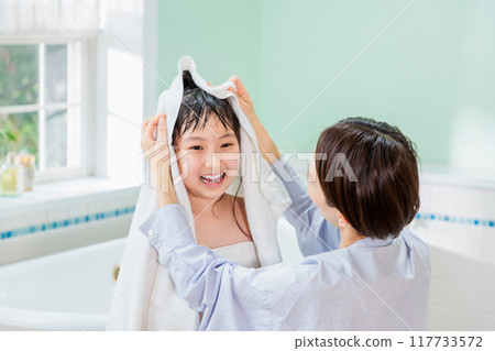A mother wipes her daughter with a towel after a bath A mother wipes her daughter with a towel after a bath 117733572