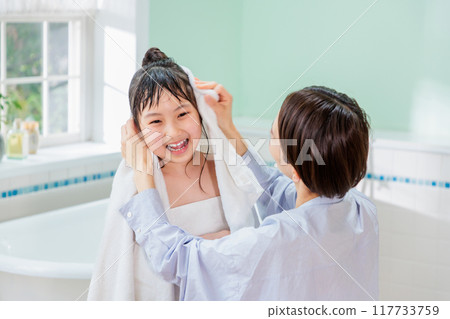 A mother wipes her daughter with a towel after a bath A mother wipes her daughter with a towel after a bath 117733759