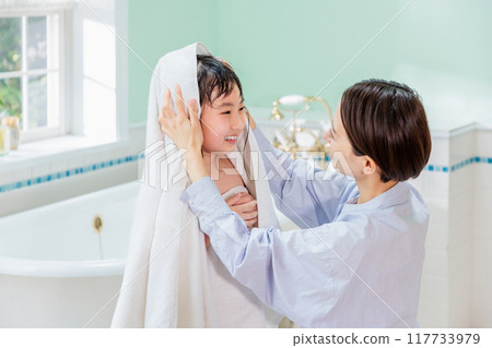 A mother wipes her daughter with a towel after a bath A mother wipes her daughter with a towel after a bath 117733979