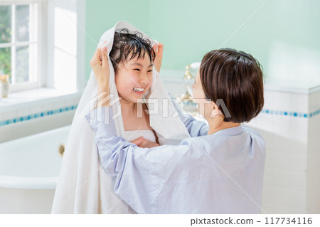 A mother wipes her daughter with a towel after a bath 117734116