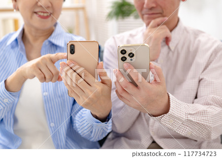 Senior couple with smartphone thinking 117734723