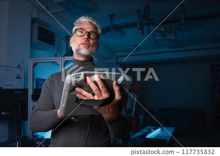 Automation engineer, technician holding remote controller of robotic arm. Concept of modern technology in industries, automated processes, robotics. 117735832