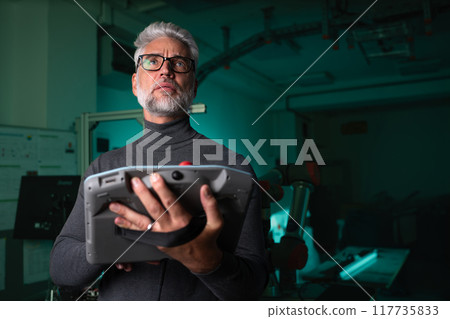 Automation engineer, technician holding remote controller of robotic arm. Concept of modern technology in industries, automated processes, robotics. 117735833