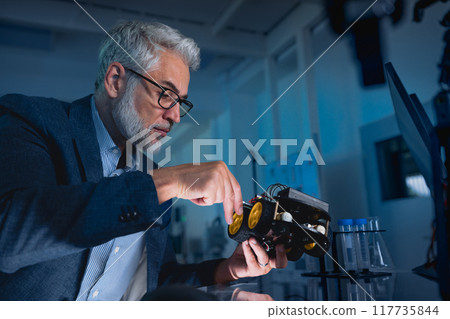 Automation, robotics engineer assembling robotic car prototype for delivery, warehouse. Concept of modern technology in industries, automated processes, automotive 117735844