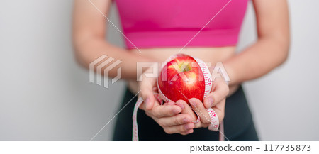 woman hand hold red Apple, happy female fitness choose fruit is Healthy food. Dieting control, Weight loss, Obesity, eating lifestyle and nutrition concepts 117735873