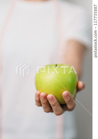 woman hand hold green Apple, happy female fitness choose fruit is Healthy food. Dieting control, Weight loss, Obesity, eating lifestyle and nutrition concepts woman hand hold green Apple, happy female fitness choose fruit is Healthy food. Dieting control, Weight loss, Obesity, eating lifestyle and nutrition concepts 117735887
