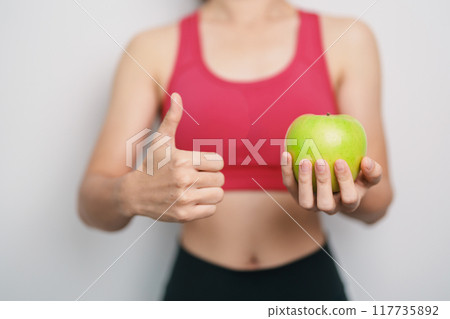 woman hand hold green Apple, happy female fitness choose fruit is Healthy food. Dieting control, Weight loss, Obesity, eating lifestyle and nutrition concepts woman hand hold green Apple, happy female fitness choose fruit is Healthy food. Dieting control, Weight loss, Obesity, eating lifestyle and nutrition concepts 117735892