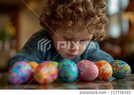 A young child is creatively adorning Easter eggs with vibrant colors.. 117736183