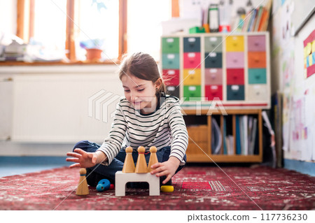 Portrait of schoolgirl using educational tool, learning while playing. Student girl in classroom at the elementary school Portrait of schoolgirl using educational tool, learning while playing. Student girl in classroom at the elementary school 117736230