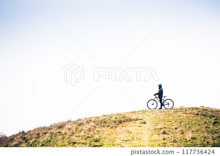 Active man on bike in the middle of beautiful nature, early autumn morning. Concept of healthy lifestyle. Active man on bike in the middle of beautiful nature, early autumn morning. Concept of healthy lifestyle. 117736424