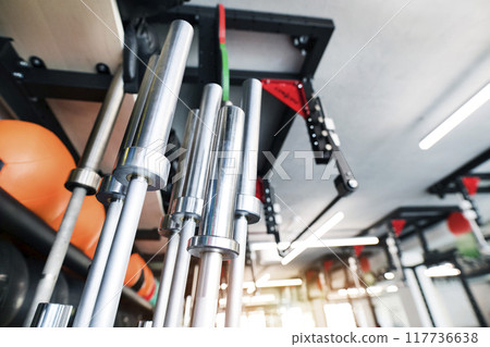 Metal bars, empty barbells in rack for strength training in gym. Metal bars, empty barbells in rack for strength training in gym. 117736638
