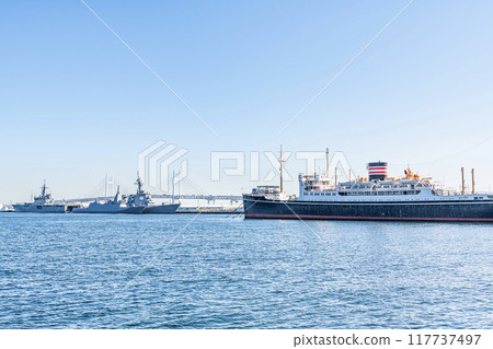 Yokohama, Kanagawa Prefecture: The Japan Maritime Self-Defense Force's escort ship and the Hikawa Maru are moored with the Yokohama Bay Bridge in the background. Yokohama, Kanagawa Prefecture: The Japan Maritime Self-Defense Force's escort ship and the Hikawa Maru are moored with the Yokohama Bay Bridge in the background. 117737497