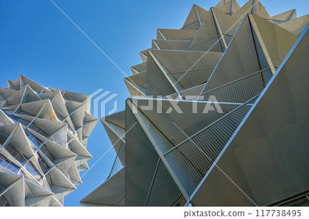 Modern residential building with geometric design against clear blue sky Modern residential building with geometric design against clear blue sky 117738495